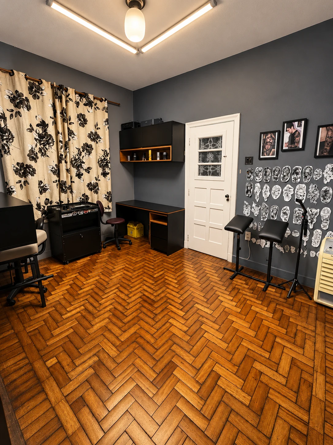 Sala de atendimento com estações de trabalho e desenhos de tatuagem